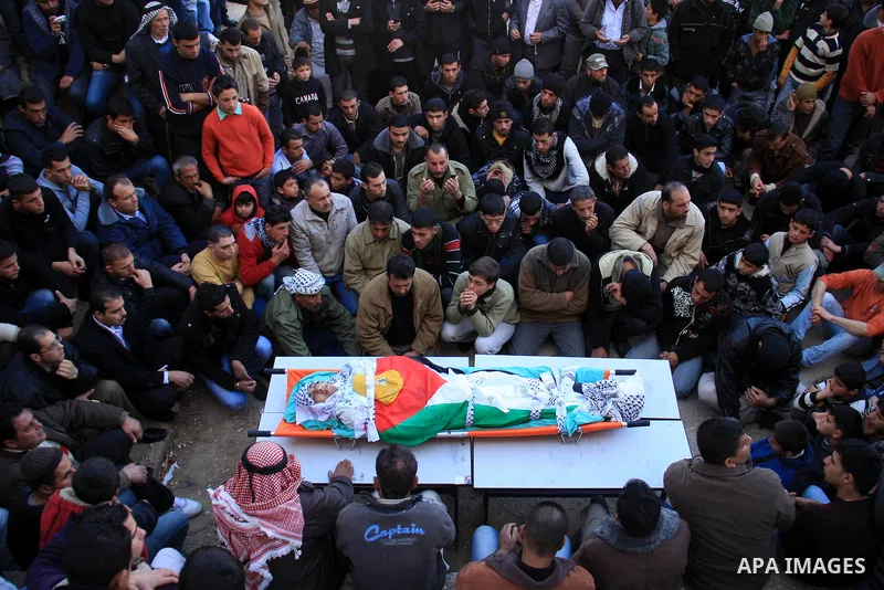 Palestinian mourners surround the body of Uday Qadous, 18, who was shot and killed Thursday in the village of Iraq Burin, during his funeral at in the West Bank city of Nablus, Friday Jan. 28, 2011. Israeli police spokes...