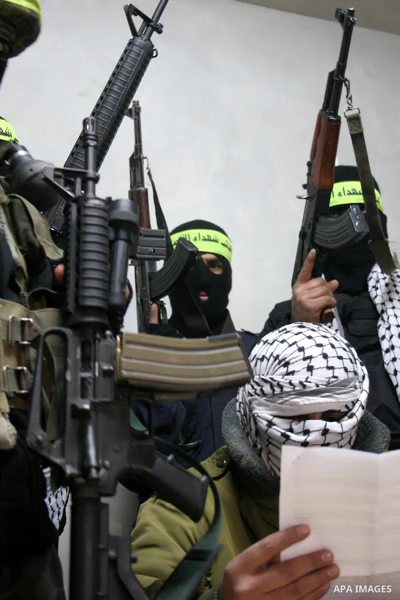 Palestinian militants of Fatah movement's armed wing 'al-Aqsa Martyrs Brigades' hold a press conference to show supports to President Mahmoud Abbas, in the West Bank city of Hebron, Jan. 27, 2011. Photo by Mamoun Wazwaz
