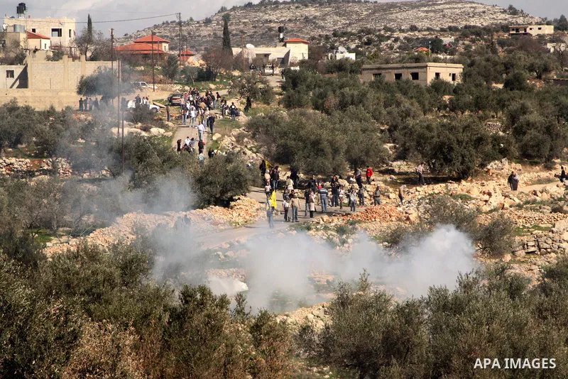 Israeli sildiers fire tear gas canisters towards Palestinian protesters during a protest against Israel's controversial separation barrier in the village of Bilin, near the West Bank city of Ramallah, on Jan. 28, 2011. P...