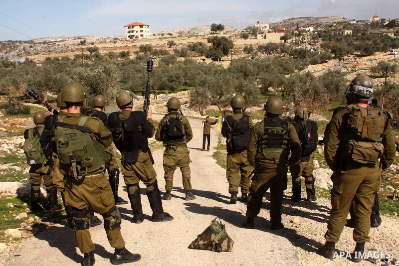 Israeli sildiers fire tear gas canisters towards Palestinian protesters during a protest against Israel's controversial separation barrier in the village of Bilin, near the West Bank city of Ramallah, on Jan. 28, 2011. P...