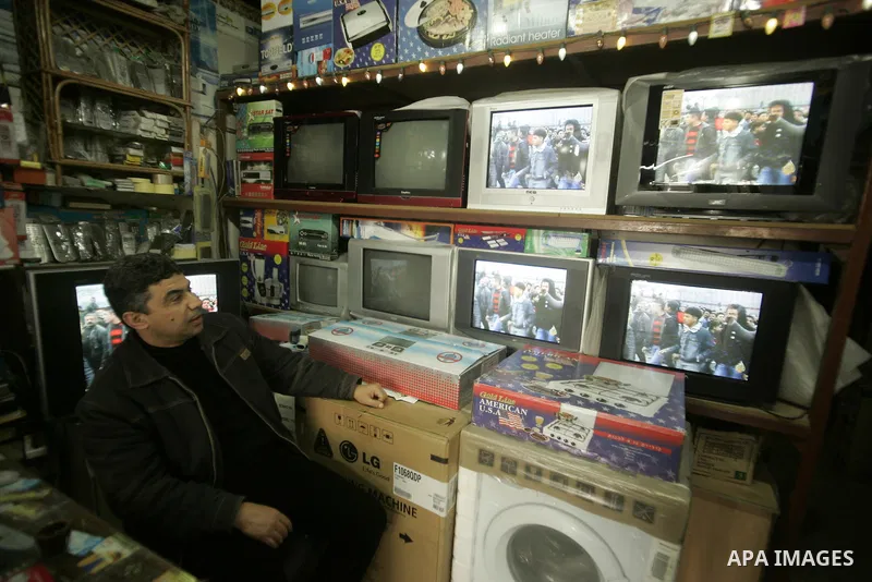 A Palestinian man looks on the television to watch the hot events in Egypt, in Rafah, southern Gaza Strip on January 29, 2011. Protest demonstrations continued in central Cairo after the government-ordered overnight curf...