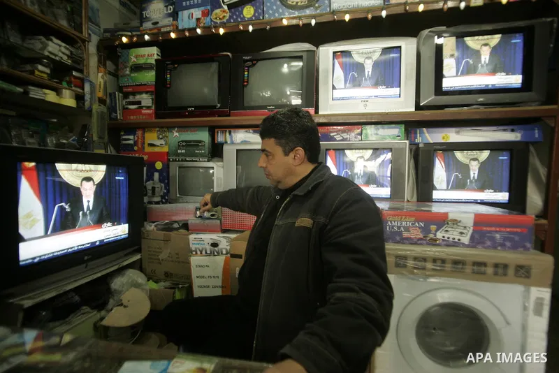 A Palestinian man looks on the television to watch the hot events in Egypt, in Rafah, southern Gaza Strip on January 29, 2011. Protest demonstrations continued in central Cairo after the government-ordered overnight curf...