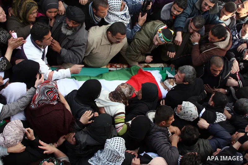 Palestinians carry the body of Youssef Ekhaleil during his funeral in the West Bank village of Beit Omar, near Hebron, Saturday, Jan. 29, 2011. Ekhaleil died from wounds sustained during a clash with settlers on Friday P...