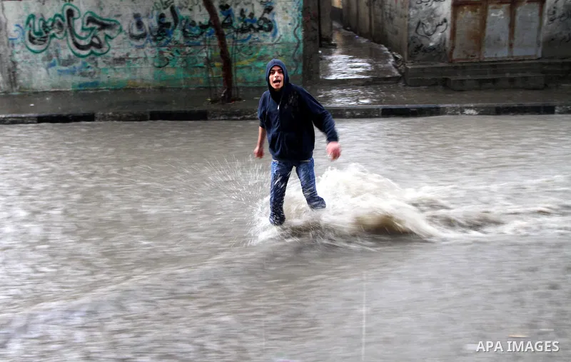 A Palestinian boy walks through a rain flooded street in Gaza City, Sunday, Jan. 30 , 2011. Photo by Ashraf Amra