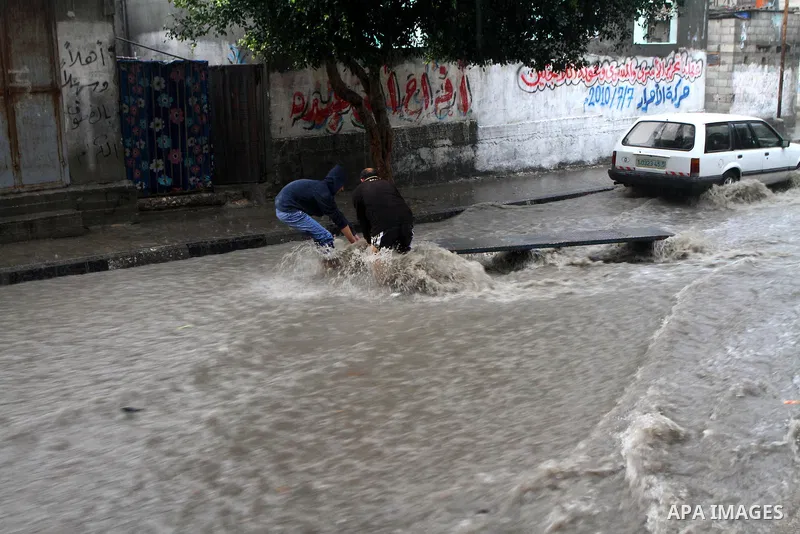 Palestinians walk through a rain flooded street in Gaza City, Sunday, Jan. 30 , 2011. Photo by Ashraf Amra