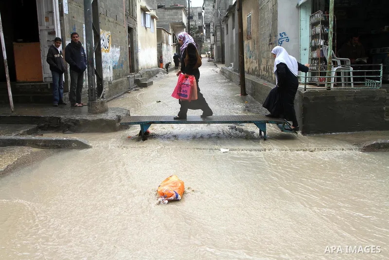 Palestinian women walk through a rain flooded street in Gaza City, Sunday, Jan. 30 , 2011. Photo by Ashraf Amra