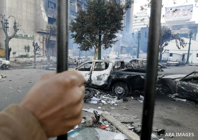 An Egyptian man looks at charred vehicles in Cairo, Egypt, Sunday, Jan. 30, 2011. Photo by STR