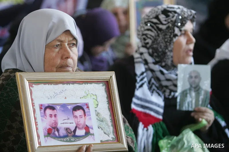 Palestinian women and children hold pictures of jailed relatives during a protest calling for the release of Palestinian prisoners from Israeli jails at the Red Cross office in Gaza City on Jan. 31, 2011. Photo by Mohamm...