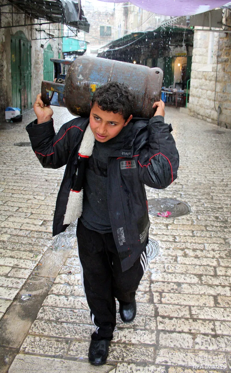 A Palestinian boy walks in the market during heavy rains in the old city of West Bank city of Hebron January 31, 2011. Photo by Najeh Hashlamoun