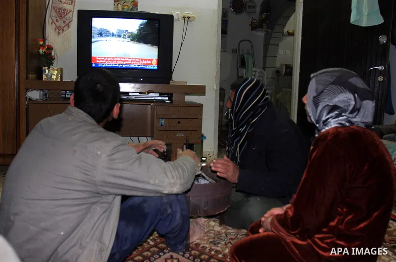 Palestinians watch television at their home to follow up on the latest developments in Egypt, in the West Bank town of Nablus on Jan. 31, 2011. Photo by Wagdi Eshtayah
