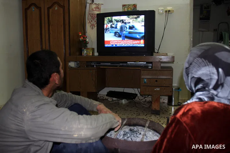 Palestinians watch television at their home to follow up on the latest developments in Egypt, in the West Bank town of Nablus on Jan. 31, 2011. Photo by Wagdi Eshtayah