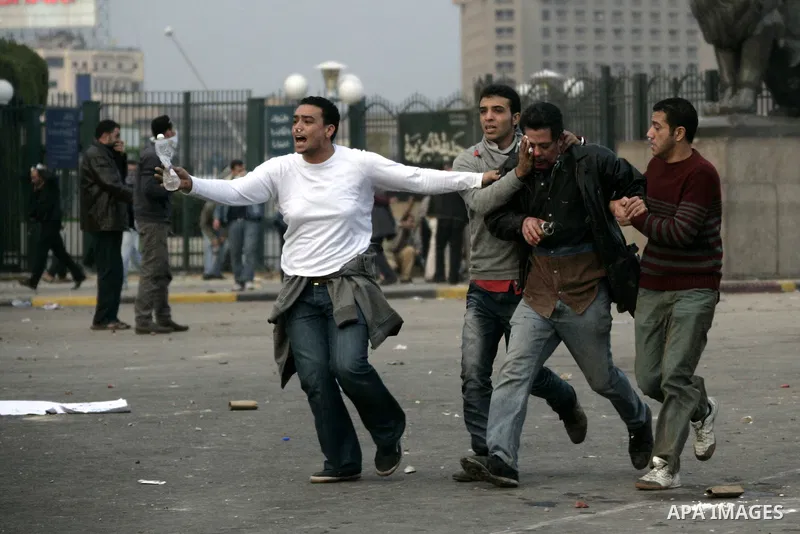 Egyptian protesters carry an injured man during demonstrations that erupted following Friday prayers in Cairo, Egypt, 28 January 2011. Photo by Karam Nasser