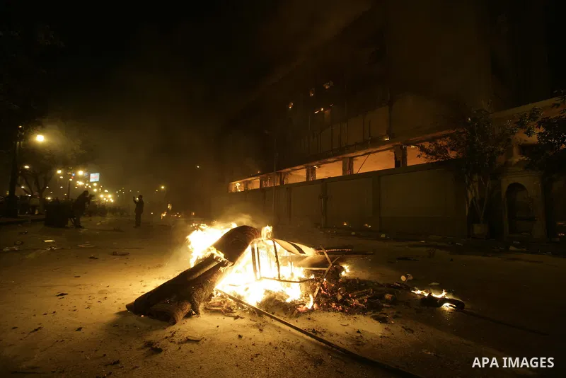 Egyptian protesters walk past fires lit at the doors of the ruling National Democratic Party (NDP) headquarters after demonstrations erupted following Friday prayers in Cairo, Egypt, 28 January 2011. Photo by Karam Nasse...