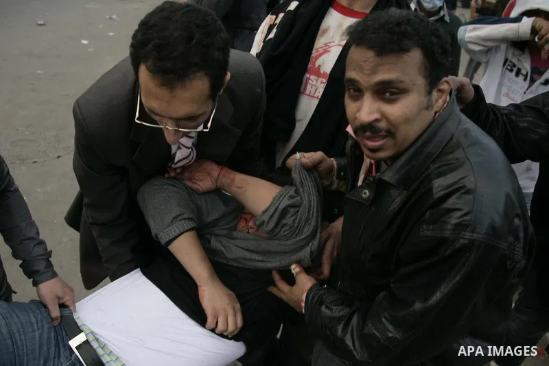 Egyptian protesters carry an injured man during demonstrations that erupted following Friday prayers in Cairo, Egypt, 28 January 2011. Photo by Karam Nasser