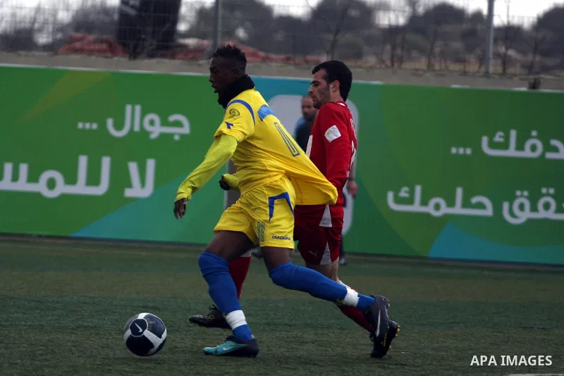 Palestinians play a football match between Tulkarem Center club (yellow) and Al-Beraeh Foundation club (red) in the occupied West Bank on Feb. 1,2011. Photo by Issam Rimawi