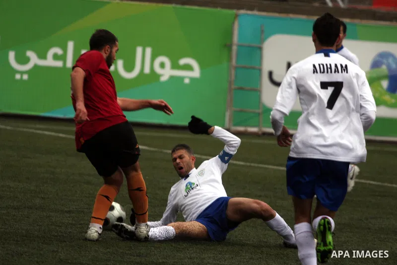 Palestinians play a football match between Tulkarem Cultural club and Balata Camp club in the occupied West Bank on Feb. 1,2011. Photo by Issam Rimawi