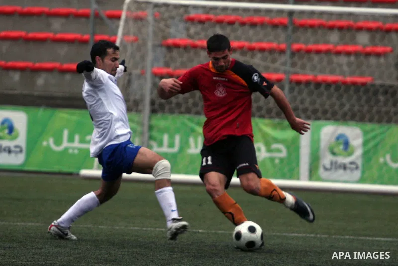 Palestinians play a football match between Tulkarem Cultural club and Balata Camp club in the occupied West Bank on Feb. 1,2011. Photo by Issam Rimawi