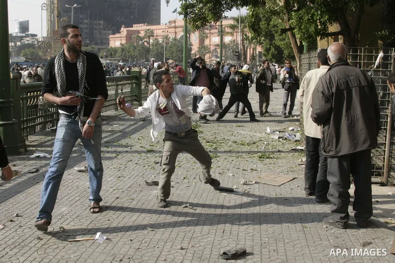 Protestors from the pro-Mubarak camp throw stones and push back the anti-Mubarak protestors on a street leading into Tahrir Square in central Cairo, Egypt on 02 February 2011. Several thousands pro-Mubarak supporters mar...