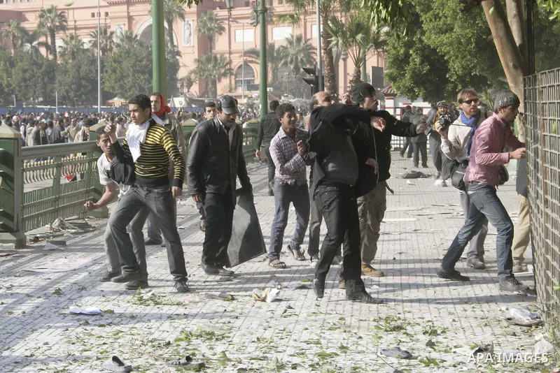 Protestors from the pro-Mubarak camp throw stones and push back the anti-Mubarak protestors on a street leading into Tahrir Square in central Cairo, Egypt on 02 February 2011. Several thousands pro-Mubarak supporters mar...