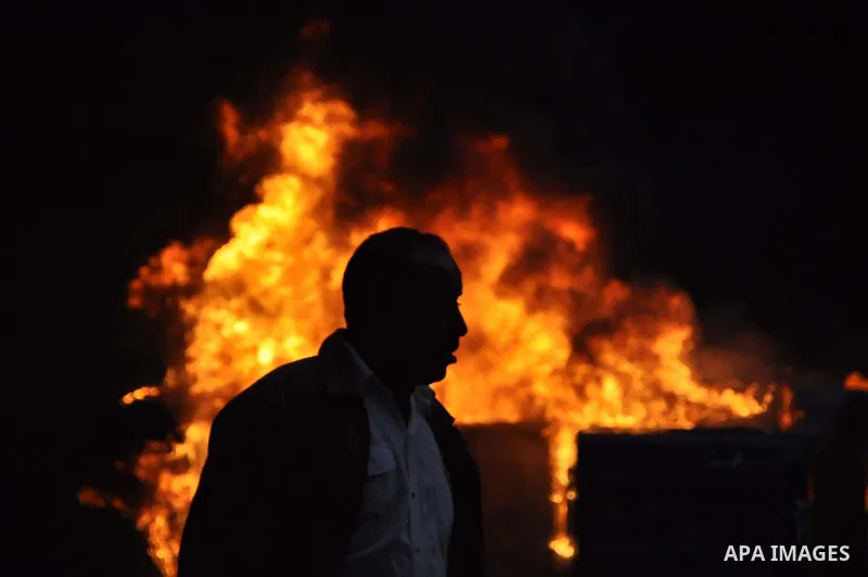 An Egyptian protester walks past fire during a protest in Alexandria, Egypt, Jan. 28, 2011. Egyptian President Hosni Mubarak defied a quarter-million protesters demanding he step down immediately, announcing he would ser...