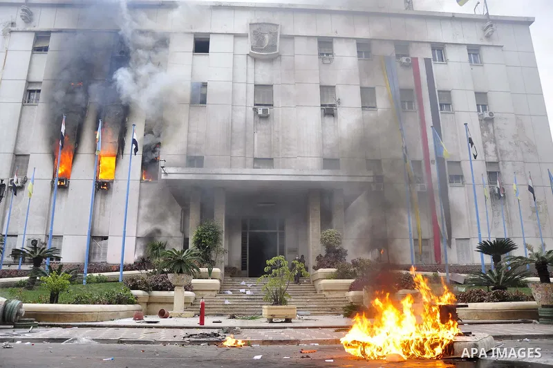 Fire rages outside the building during a anti-government protesters demonstrate against president Hosni Mubarak regime in Alexandria, Egypt, Jan. 28, 2011. Egyptian President Hosni Mubarak defied a quarter-million protes...