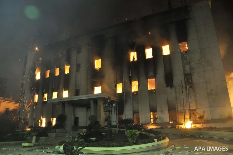 Fire rages outside the building during a anti-government protesters demonstrate against president Hosni Mubarak regime in Alexandria, Egypt, Jan. 28, 2011. Egyptian President Hosni Mubarak defied a quarter-million protes...