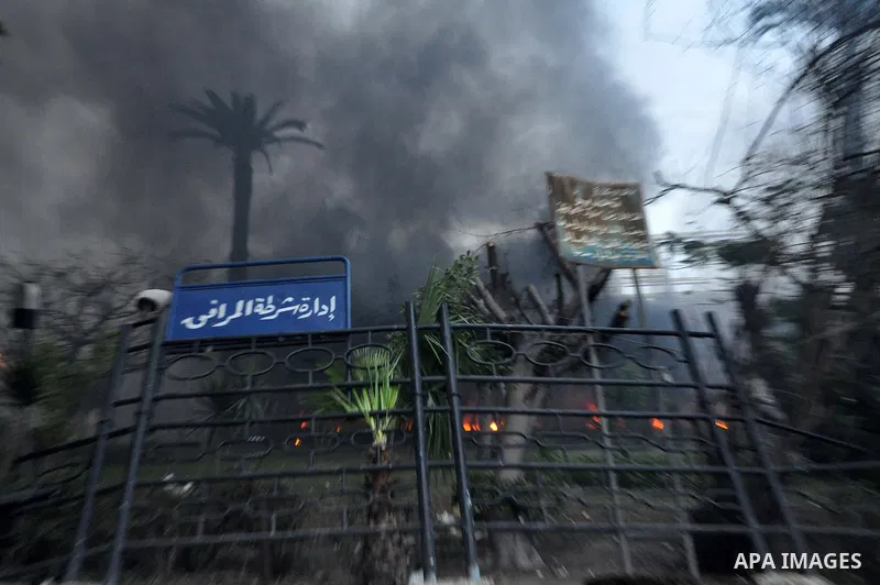 Fire rages outside the building during a anti-government protesters demonstrate against president Hosni Mubarak regime in Alexandria, Egypt, Jan. 28, 2011. Egyptian President Hosni Mubarak defied a quarter-million protes...