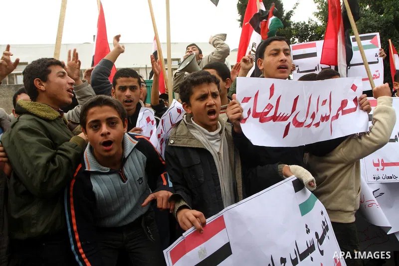 Palestinian protesters wave Egyptian flags and shout slogans during a demonstration outside the offices of the Egyptian diplomatic mission in Gaza City on February 3, 2011 in support of the anti-government protests in Eg...