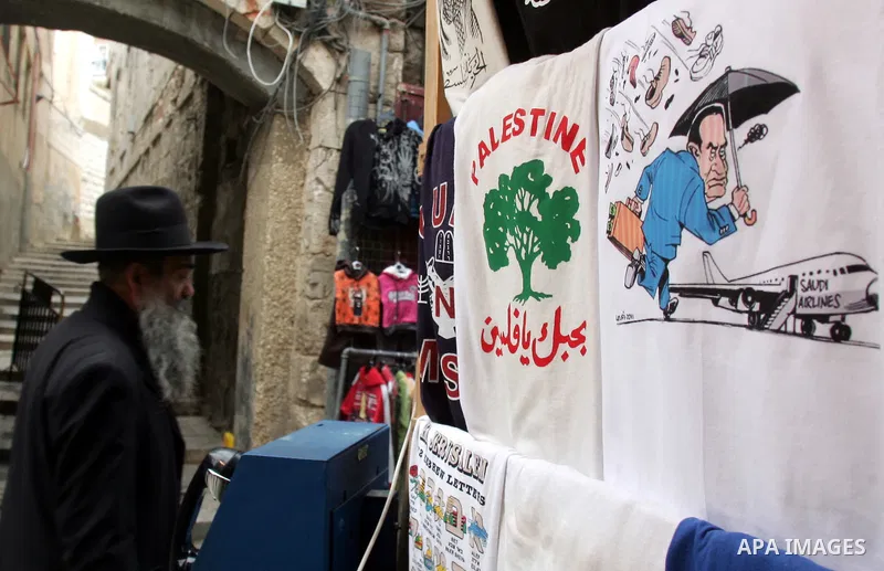An Orthodox Jewish man passes next to a shirt printed with a caricature picture for the Egyptian President Hosni Mubarak in the old city of Jerusalem on Feb. 3,2011. Photo by Mahfouz Abu Turk