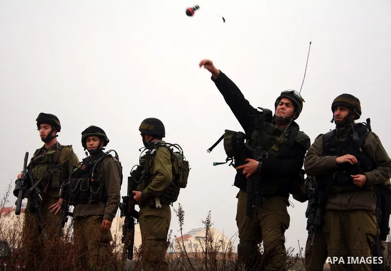 Israeli soldiers stand guard and fire tear gas during a protest against Israel's controversial separation barrier in the West Bank village of Wad Rahal,near the biblical town of Bethlehem, on February 04, 2011. Israel sa...