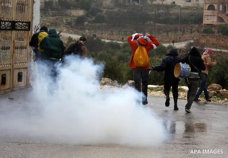 Palestinians, foreign protesters and leftwing Israeli peace activists run for cover during a protest against Israel's controversial separation barrier in the West Bank village of Wad Rahal,near the biblical town of Bethl...