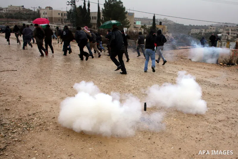 Palestinians, foreign protesters and leftwing Israeli peace activists run for cover during a protest against Israel's controversial separation barrier in the West Bank village of Wad Rahal,near the biblical town of Bethl...