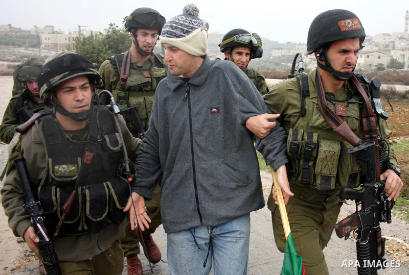 Israeli soldiers arrest a demonstrator during a protest against Israel's controversial separation barrier in the West Bank village of Wad Rahal,near the biblical town of Bethlehem, on February 04, 2011. Israel says the n...