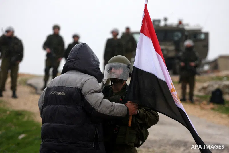A Palestinian protester holds an Egyptian flag in support of the Egyptian people during a protest against Israel's separation barrier in the West Bank village of Bilin near Ramallah, Friday, Feb 4, 2011. Photo by Issam R...