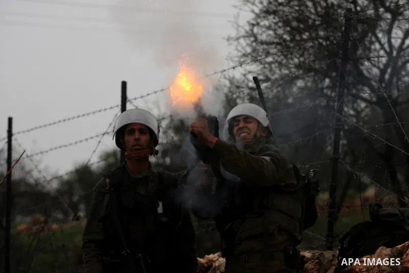 Israeli sildiers fire tear gas canisters towards Palestinian protesters during a protest in the village of Bilin on Feb. 4, 2011. Photo by Issam Rimawi