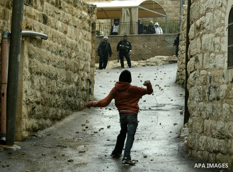 Palestinian youths throw stones towards Israeli border police during clashes in the East Jerusalem neighbourhood of Ras al-Amud on February 04, 2011. Photo by Mahfouz Abu Turk