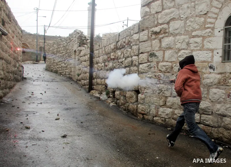 Palestinian youths throw stones towards Israeli border police during clashes in the East Jerusalem neighbourhood of Ras al-Amud on February 04, 2011. Photo by Mahfouz Abu Turk