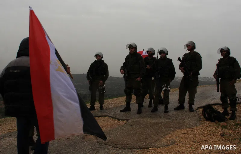 A Palestinian protester holds an Egyptian flag in support of the Egyptian people during a protest against Israel's separation barrier in the West Bank village of Bilin near Ramallah, Friday, Feb 4, 2011. Photo by Wagdi E...
