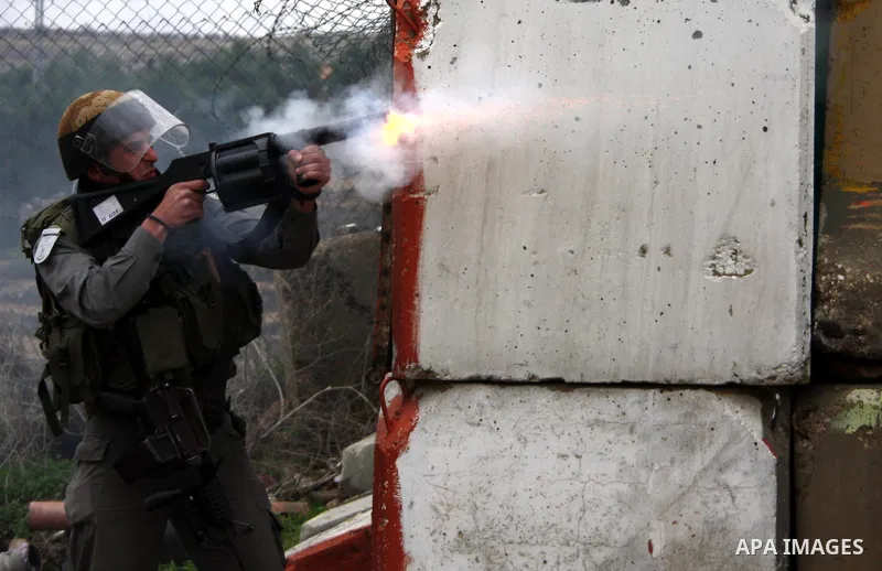 An Israeli soldier fires a tear gas towards Palestinian protesters during a demonstration against the Israeli controversial separation barrier in the West Bank village of Beit Omar, near Hebron, 05 February 2011. Israel...