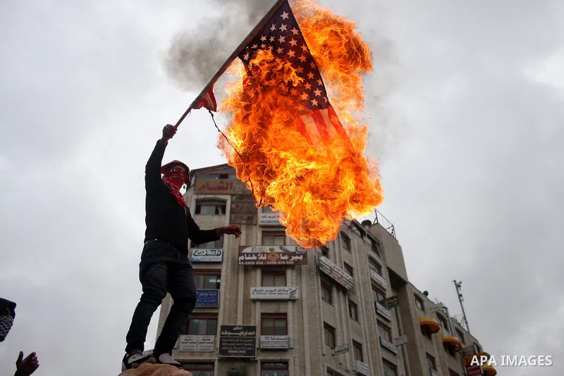A Palestinian protester burns an American flag during a demonstration in support of the Egyptian people in the West Bank city of Ramallah, Saturday, Feb. 5, 2011. Photo by Issam Rimawi