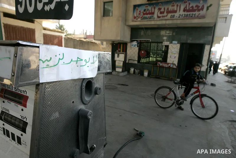 A Palestinian boy rides his bike near a petrol station in Rafah, southern Gaza Strip on February, 06, 2011. Fuel stations in the Gaza Strip free of fuel, due to suspension of the fuel line through border tunnels between...