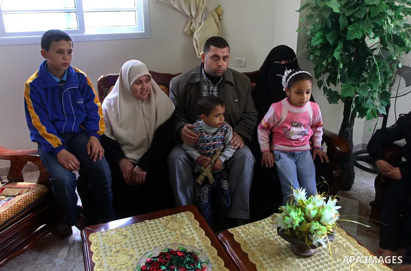 Ayman Nofal (C), a top Hamas armed commander, sits with his family at his home in Nusairat in the Central Gaza strip on February 6, 2011. A senior Hamas commander returned to the Gaza Strip on Saturday after breaking out...