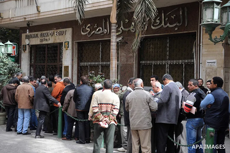 Customers queue at Egypt banks in Cairo February 6, 2011. Egypt banks to allow transfers, limit cash withdrawals . Egypt's banks open today for the first time in more than a week amid investor concern that a possible run...