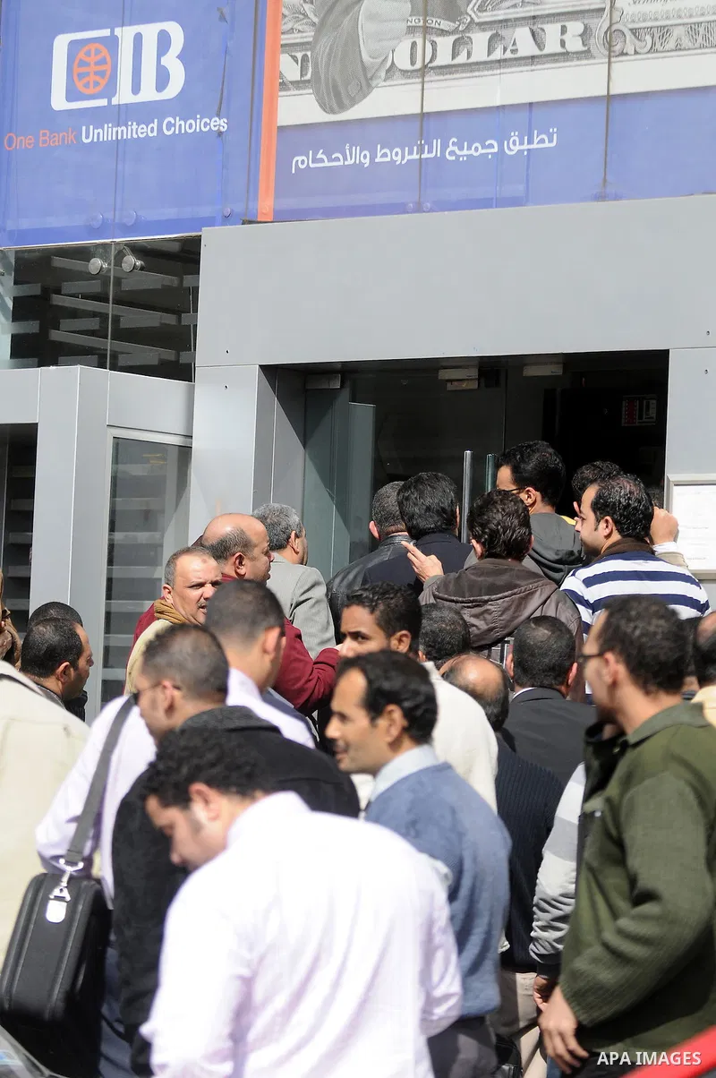 Customers queue at Egypt banks in Cairo February 6, 2011. Egypt banks to allow transfers, limit cash withdrawals . Egypt's banks open today for the first time in more than a week amid investor concern that a possible run...