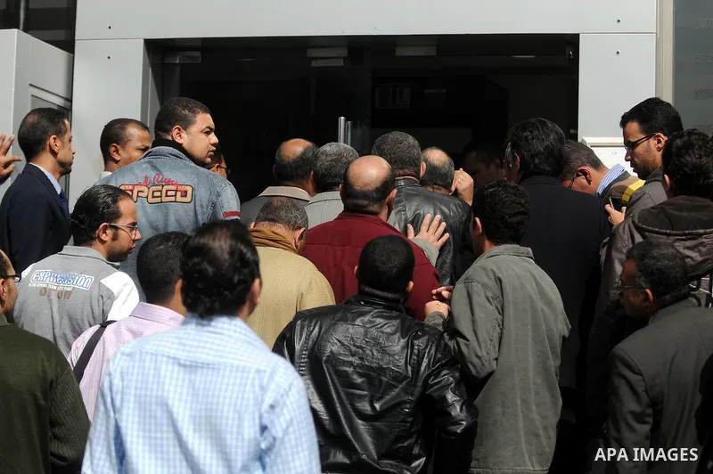 Customers queue at Egypt banks in Cairo February 6, 2011. Egypt banks to allow transfers, limit cash withdrawals . Egypt's banks open today for the first time in more than a week amid investor concern that a possible run...