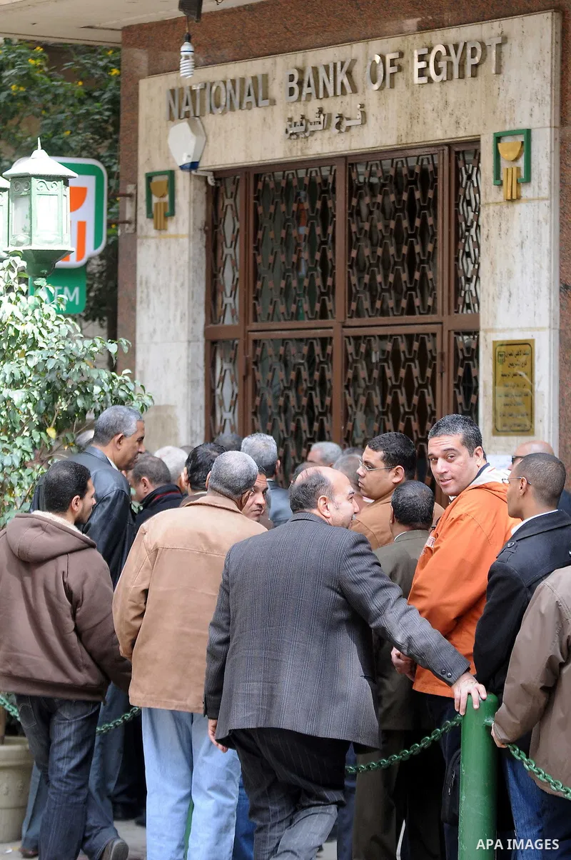 Customers queue at Egypt banks in Cairo February 6, 2011. Egypt banks to allow transfers, limit cash withdrawals . Egypt's banks open today for the first time in more than a week amid investor concern that a possible run...