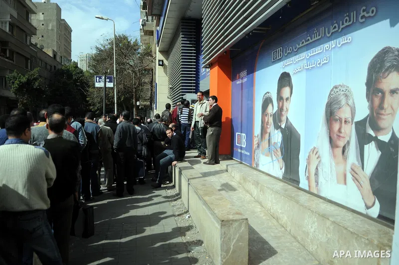 Customers queue at Egypt banks in Cairo February 6, 2011. Egypt banks to allow transfers, limit cash withdrawals . Egypt's banks open today for the first time in more than a week amid investor concern that a possible run...