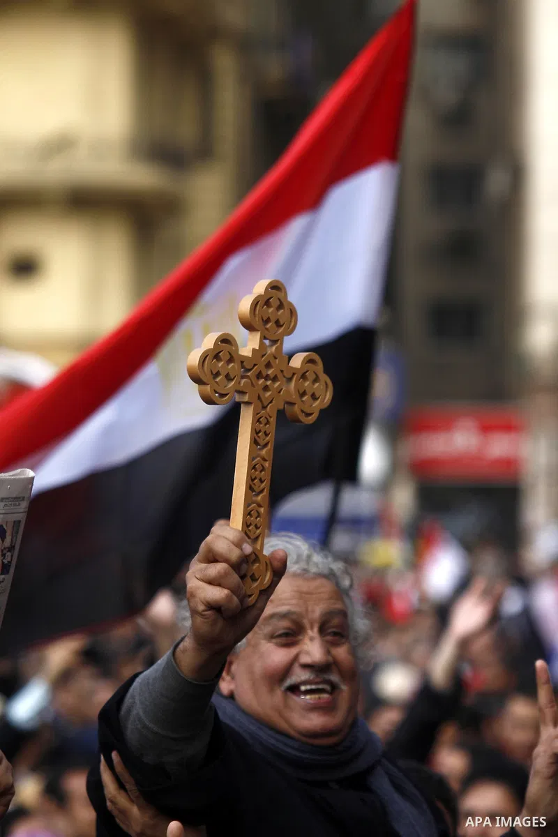 An opposition supporter holds a cross in Tahrir Square in Cairo February 6, 2011. Demonstrators camped out in Cairo's Tahrir Square, which has become an epicentre for protest, vowed to intensify their battle to oust Egyp...