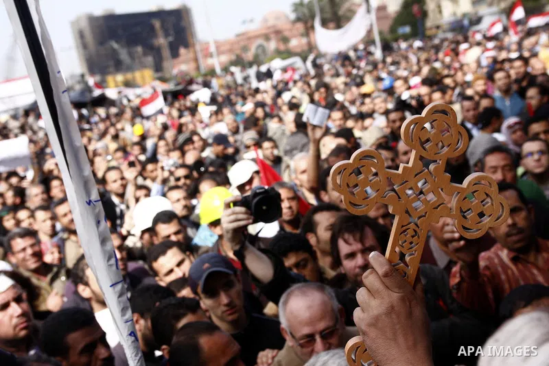 Opposition supporters hold a cross in Tahrir Square in Cairo February 6, 2011. Demonstrators camped out in Cairo's Tahrir Square, which has become an epicentre for protest, vowed to intensify their battle to oust Egypt's...