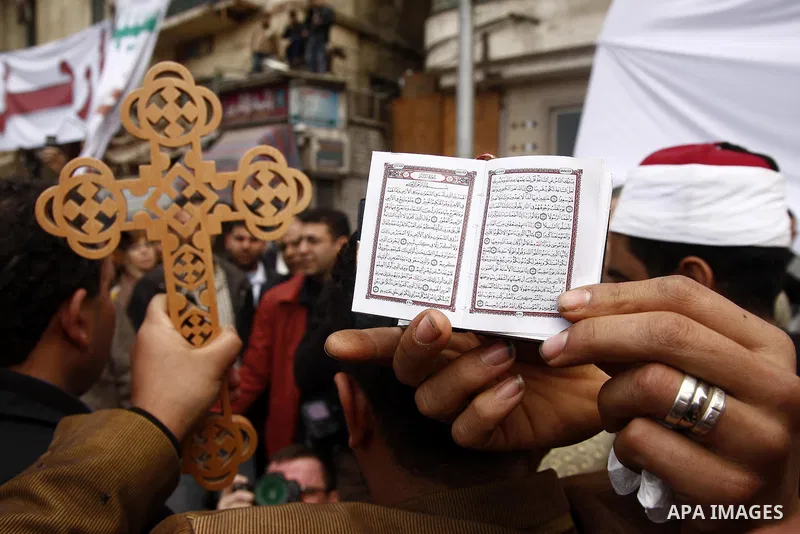 Opposition supporters hold Holy Quran and a cross in Tahrir Square in Cairo February 6, 2011. Demonstrators camped out in Cairo's Tahrir Square, which has become an epicentre for protest, vowed to intensify their battle...
